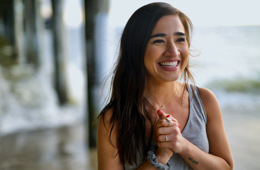 Smiling woman with long dark hair looking past the camera