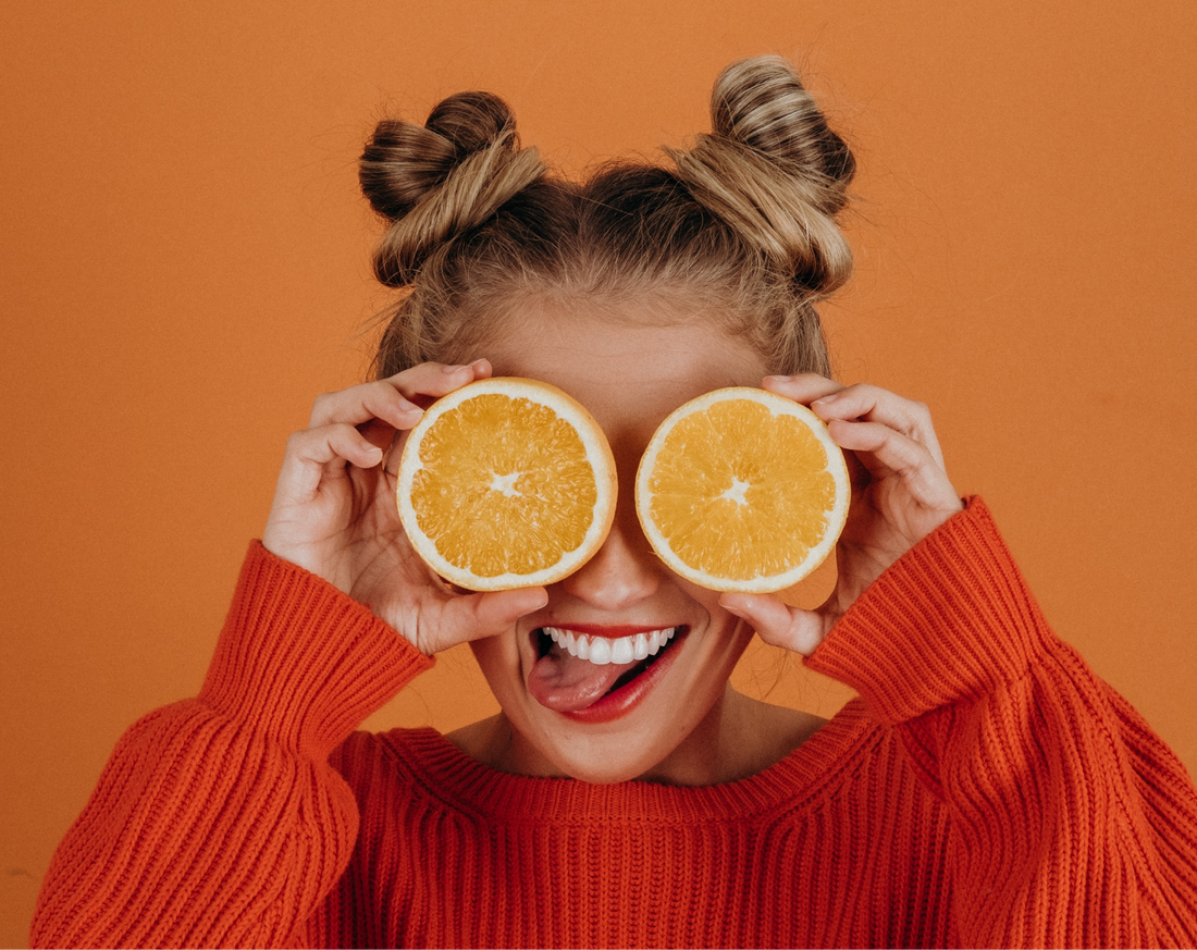 woman holds oranges up to eyes